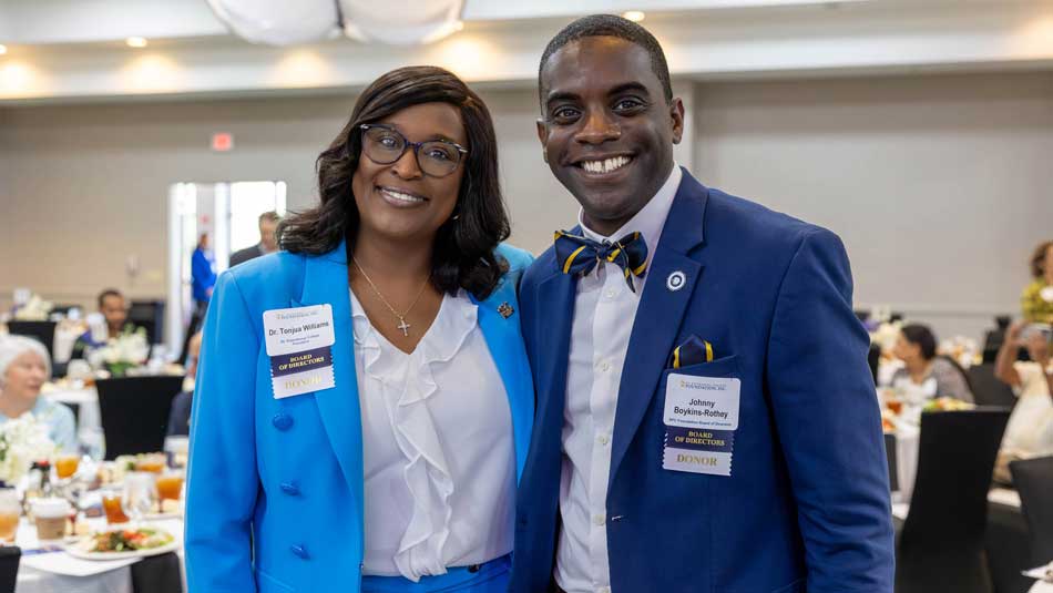 Dr Williams and Boykins at a conference smiling at the camera