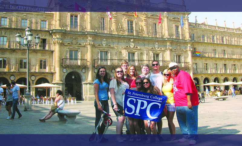 group of SPC students holding an SPC banner in front of a Spanish castle