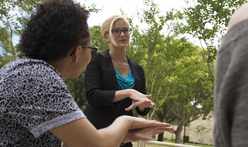 female student speaking to an instructor in American Sign language