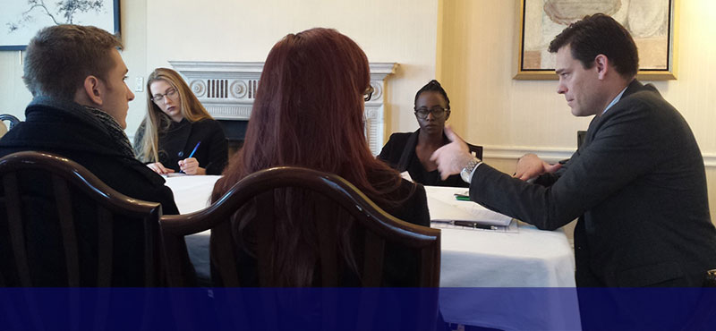 group of students and policymakers at a table