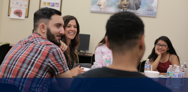 group of students interacting around a table in a classroom