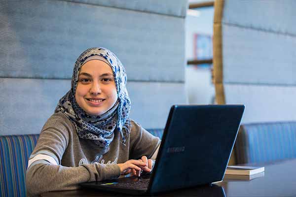 An SPC student posing for a photo while working on her laptop