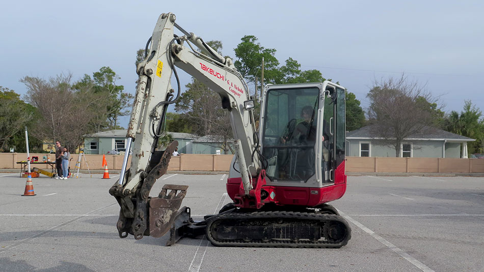 male student operating a heavy equipment excavator