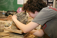 student sculpting clay