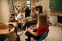 female students critiquing artwork in a classroom